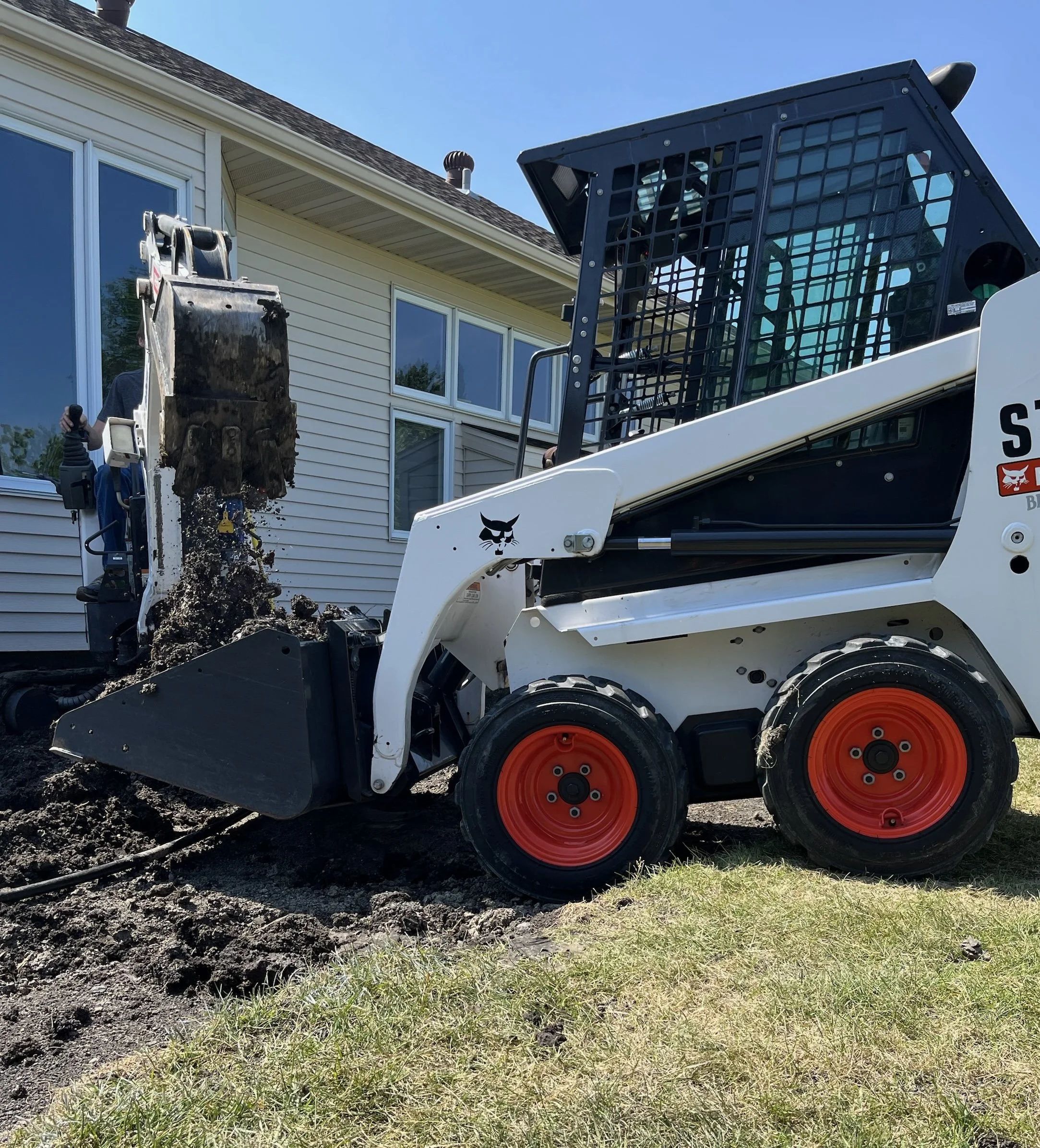 Skid steer grading for new construction